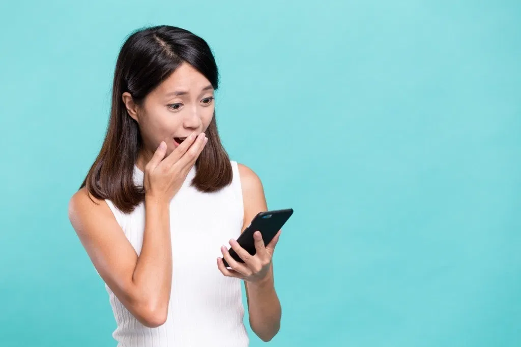 shocked woman looking at a phone against a light blue background, did you know facts